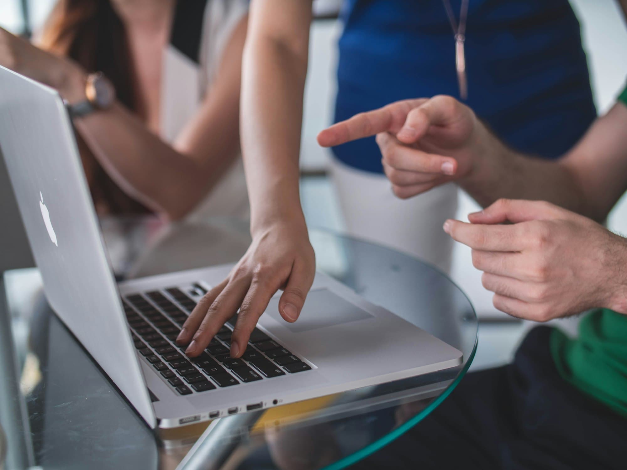 A small team discussing work around a laptop