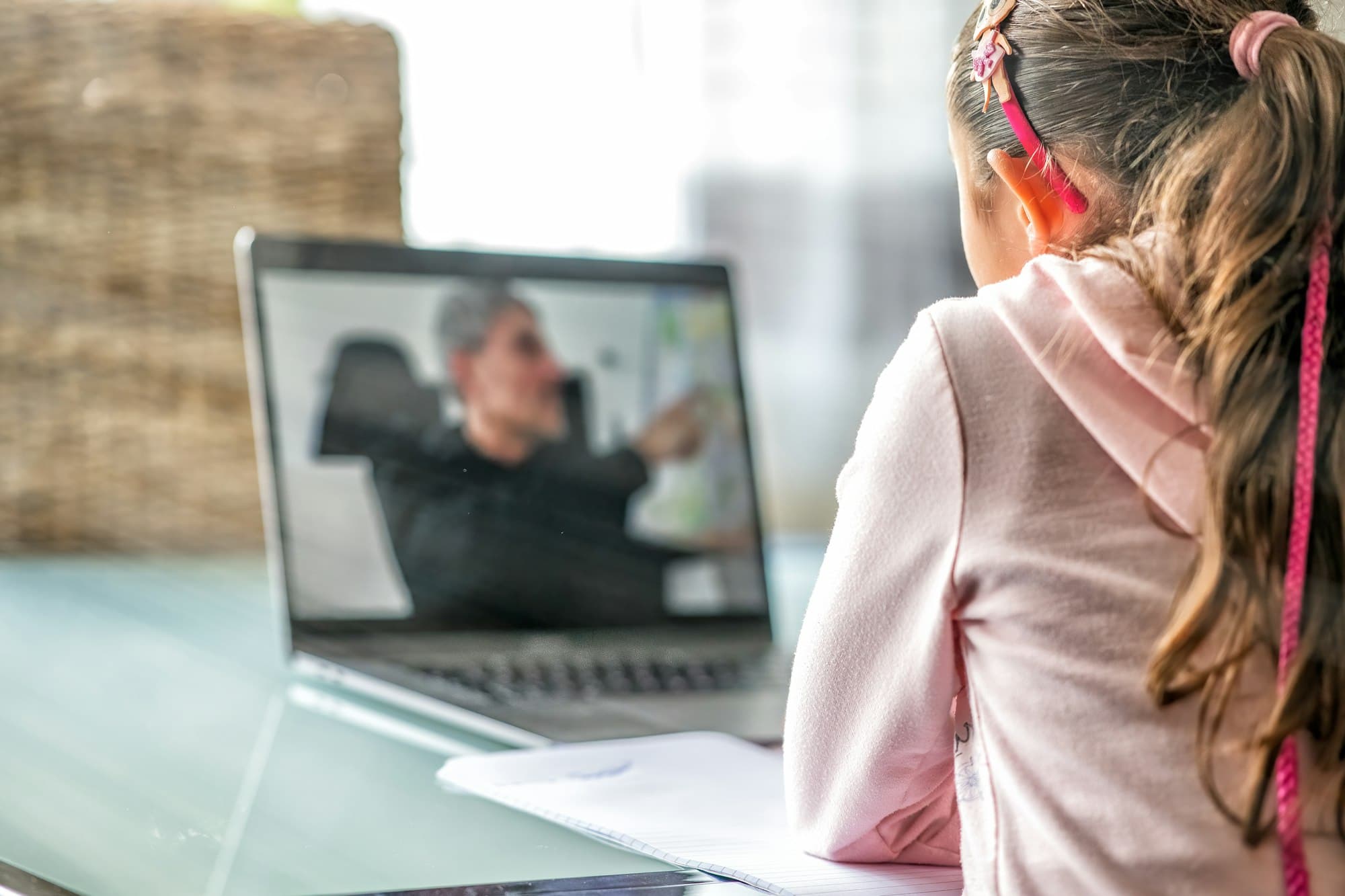 A girl on a video call with her tutor on a laptop